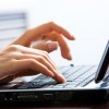 Closeup of a happy young businesswoman lying on sofa and using laptop