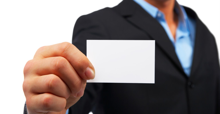 A studio shot of a businessman holding out a blank business card. Room for text, or your own message.